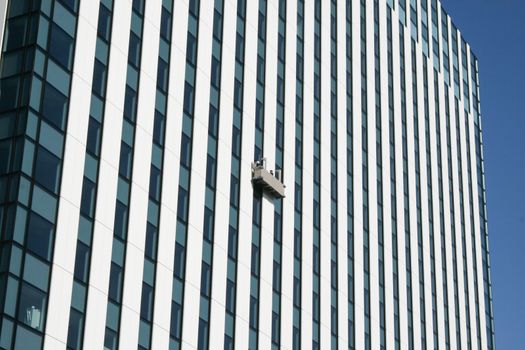 Gondola with window two cleaners on skyscraper