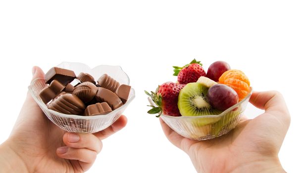 Choose healthy foods. Bowl with chocolates and a bowl of fruit