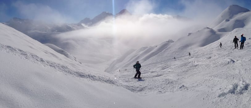 A skier on the piste in front of beautiful mountains