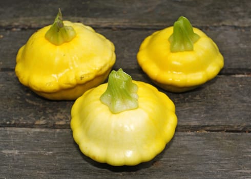  Yellow Patissons on a wooden table                              