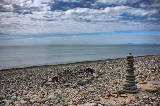 stones balancing on top of each to make a tower on a beach