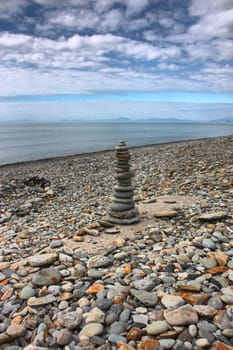 stones balancing on top of each to make a tower on a beach