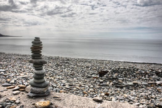 stones balancing on top of each to make a tower on a beach