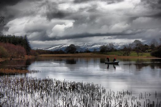 heavy clouds over a still lake in snowdonia