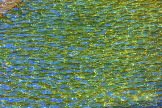 911 Memorial Pool Blue Yellow Green Reflections Pattenrs Abstract New York NY.  Pool is in the foundation of one of the Two World Trade Center Buildings.  Water falls into hole of the foundation.  