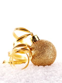 New Year's golden ball on snow with a tape. New Year's golden balls. Christmas balls. Christmas tree decorations. Christmas jewelry.