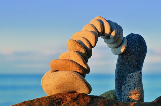 Arch of pebbles in the balance on the seacoast