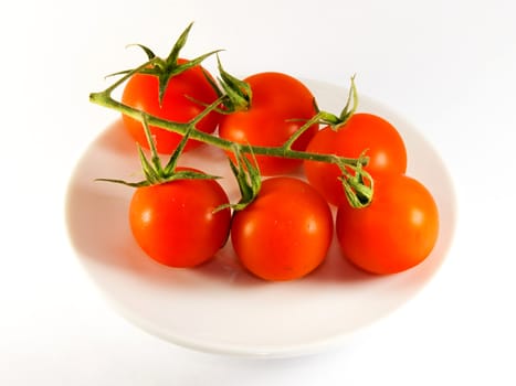 Photo presents details of red tomatoes on the white background.