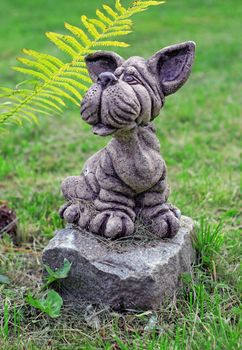 Garden stone statue of dog on the lawn