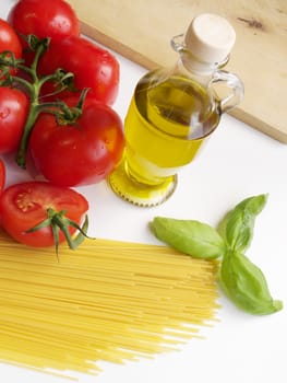 Image of fresh and genuine Italian tomatoes, spaghetti, olive oil and basil. Ingredients for mediterranean diet.