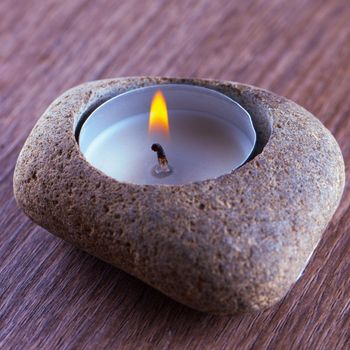 Lit candle inside a stone for decoration