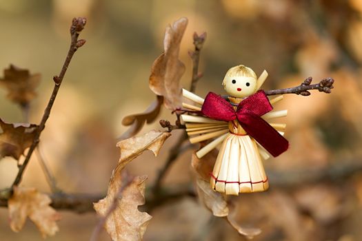 Photo shows a straw angel figurine in the wood.