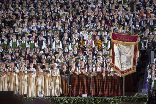 RIGA, LATVIA - July 7, 2013: The Latvian National Song and Dance Festival Grand Finale concert "Ligo!". Singers with historical festival flag.