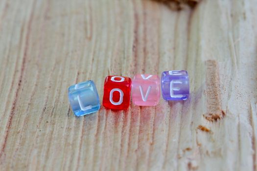 Photo shows details of love sign on the wooden background.