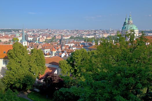 Photo shows general view onto city red roof houses.