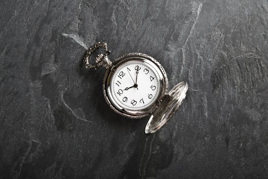 Pocket gray clock on dark gray slate texture