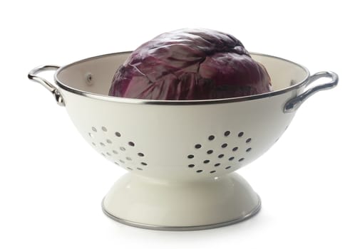 Red cabbage in the white enamel collander on the white background