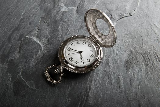 Pocket gray clock on dark gray slate texture