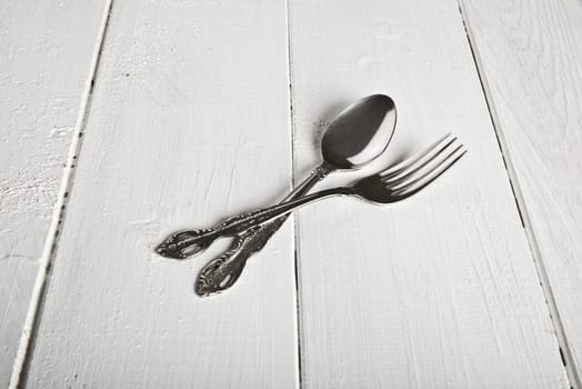 Vintage fork and spoon on white wooden table