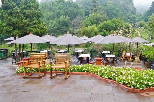 Seating area of the restaurant surrounded by trees in a forest on mountain, Thailand