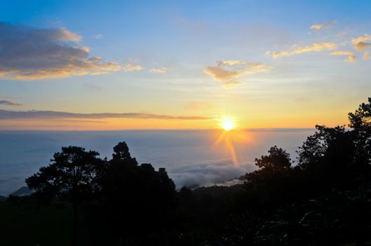 Colorful sunrise above the clouds from high mountain at viewpoint Huai Nam Dang national park in Chiang Mai and Mae Hong Son province of Thailand