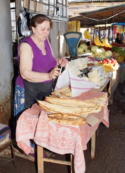 RUSTAWI, GEORGIA - JULY 3, 2014: Woman selling bread on a market on July 3, 2014 in Rustawi, Georgia, Europe.