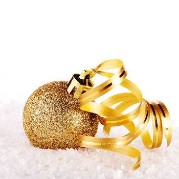 New Year's golden ball on snow with a tape. New Year's golden balls. Christmas balls. Christmas tree decorations. Christmas jewelry.
