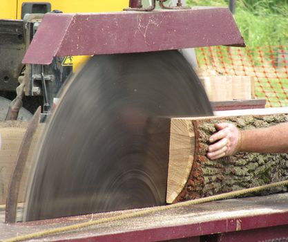 a large dangerous looking circular saw cutting wood