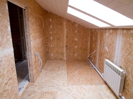 Room paneled with oriented strand board in the process of fitout