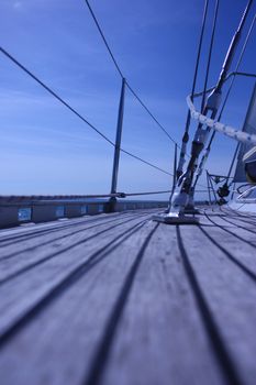 The curved teak deck of a yacht sailing at sea