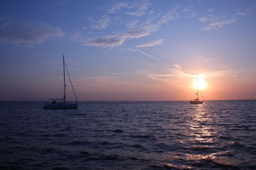 yachts at anchor in studland bay with sunrise in the background