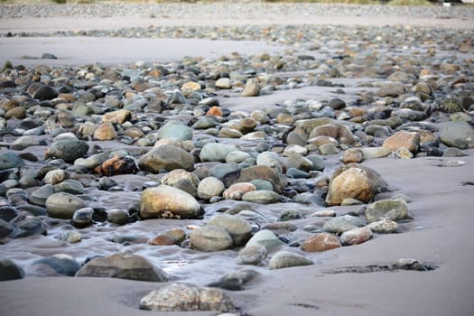 wet stone rocks on a sandy beach