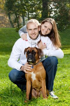 portrait of a happy young couple with their dog in the park.