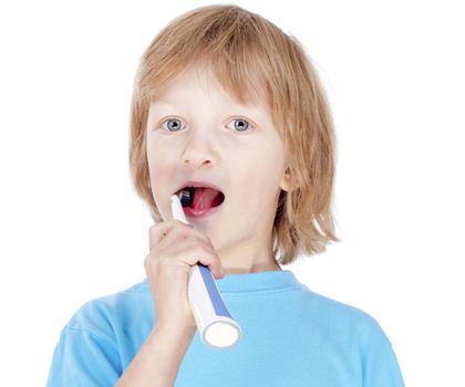 boy with blond hair in blue top brushing his teeth - isolated on white