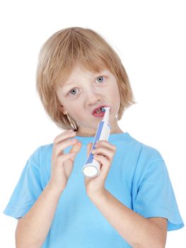boy with blond hair in blue top brushing his teeth - isolated on white