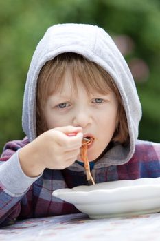 Boy with Blond Hair in Hood Eating Pasta