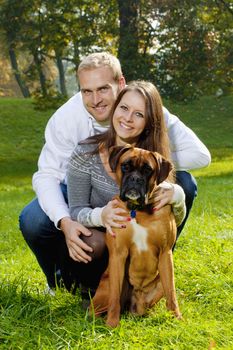 portrait of a happy young couple with their dog in the park.