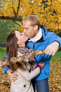 portrait of a happy young couple in the park, kissing.