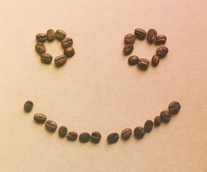 Happy face shaped of coffee beans with retro filter effect