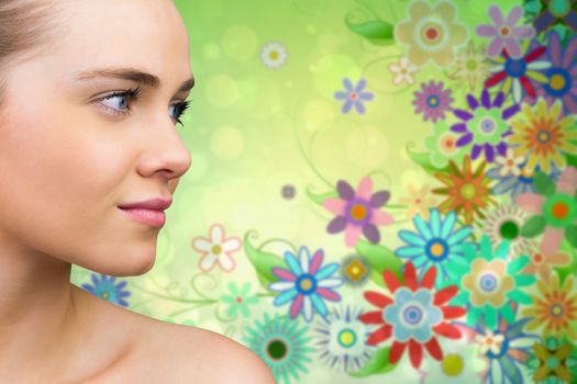 Smiling blonde natural beauty against digitally generated girly floral design