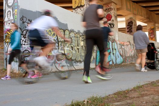 Atlanta, GA, USA - November 2, 2013:  Motion blur of several people exercising along a graffiti covered trail that is part of the Atlanta Beltline, a 22-mile long urban redevelopment project for the city of Atlanta that will eventually connect 45 intown neighborhoods.