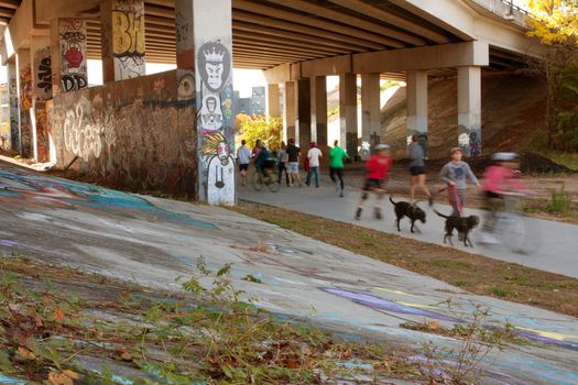 Atlanta, GA, USA - November 2, 2013:  Motion blur of several people exercising along a graffiti covered trail that is part of the Atlanta Beltline, a 22-mile long urban redevelopment project for the city of Atlanta that will eventually connect 45 intown neighborhoods.
