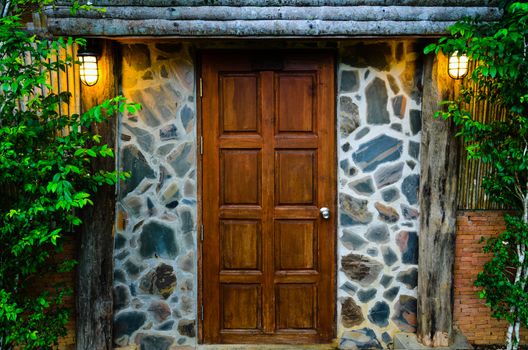Front wooden door of residence, surrounded by nature in evening