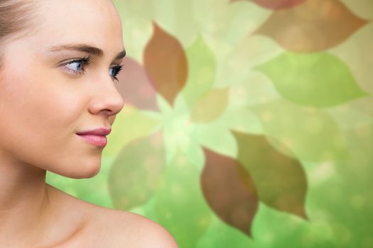 Smiling blonde natural beauty against leaf pattern in green and brown
