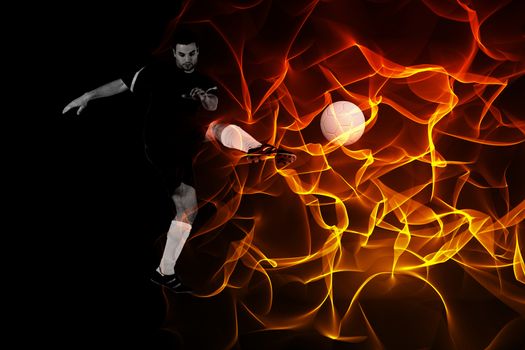 Football player in red kicking against abstract orange glowing black background