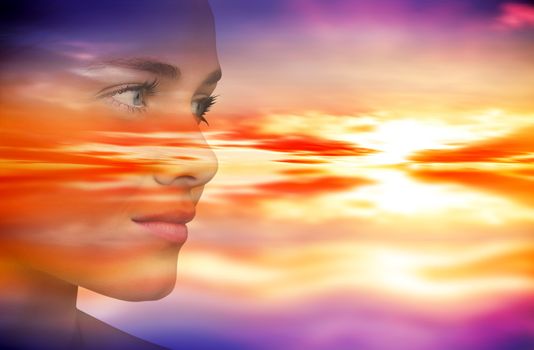 Smiling blonde natural beauty against purple sky with orange clouds