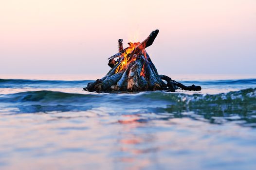 Bright campfire on the sea surface