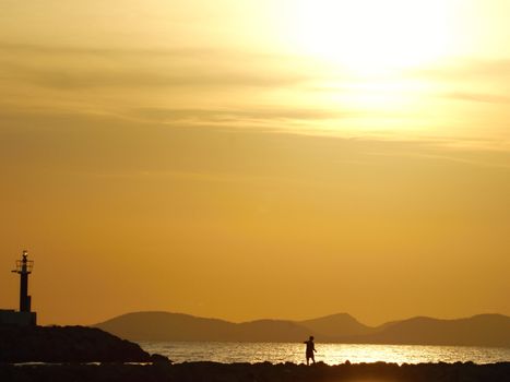 Photo is showing sunset above the beach and sea of Mallorca, Spain.