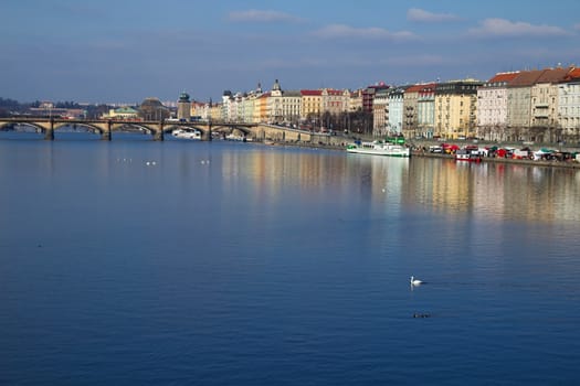 Photo shows various historical houses, Vltava river, bridges and other architectural details.