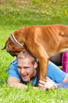 Happy Young Man Playing with his Dog in the Park.